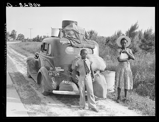 A family beside their car packed with belongings during the Great Migration, 1940